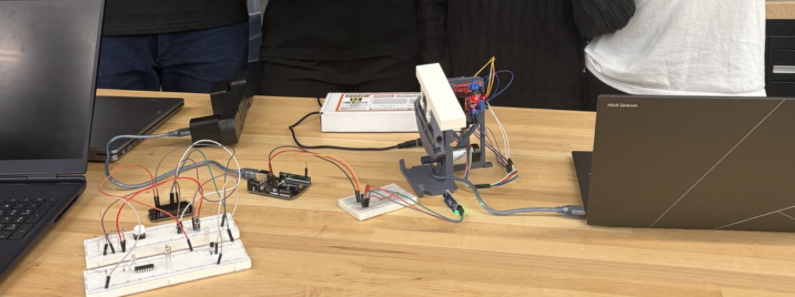 Bench setup showing the Hapkit, Arduino, breadboard, and wiring for the haptic piano system